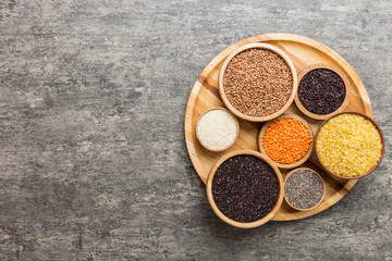 Various superfoods in smal bowl on colored background. Superfood as rice, chia, quinoa, lentils, nuts, sesame seeds, almonds. top view