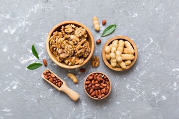 Walnut kernel halves with peanut, in a wooden bowl. Close-up, from above on colored background. Healthy eating groundnut concept. Super foods with copy space