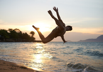 Man, dancer and breakdance with jump on beach for hip hop performance, workout training and...