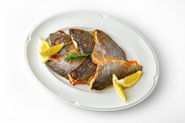 Dorado fish fillet baked with vegetables on a white plate. Banquet festive dishes. Gourmet restaurant menu. White background.