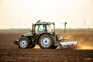 Modern tractor seeding, planting agricultural field at dusk © oticki
