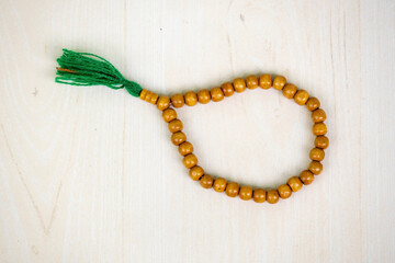 Beautiful wooden prayer beads or tasbih on a table - obrazy, fototapety, plakaty