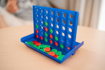 A close-up shot of a partially completed Connect Four game, showing an intense battle between red and green checkers - obrazy, fototapety, plakaty