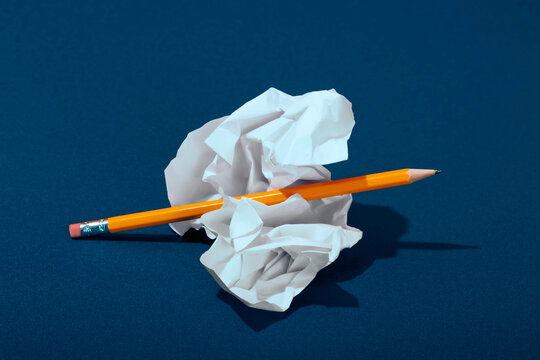 Crumpled paper with pencil on blue background