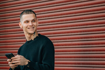 Obraz premium young man with mobile phone and bicycle on the street in red background