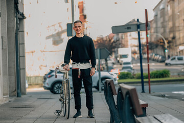 Obraz premium young man walking on the street with bicycle