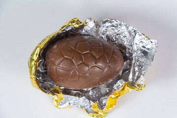 Chocolate egg for easter unwrapped from its golden paper