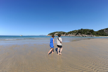 Two people walking on idyllic beach at Florence Bay, Magnetic Island, QLD, Australia