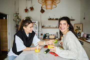 happy and cozy moment of young lesbian couple spending time in kitchen and making salad, lgbt