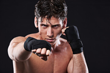 Boxing, portrait and man punching in studio for exercise, challenge or competition training for gym. Power, muscle or serious champion boxer at mma workout with confidence, fight and black background - Powered by Adobe
