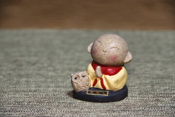 念仏お唱え手を合わす小さな人形とフクロウの置物