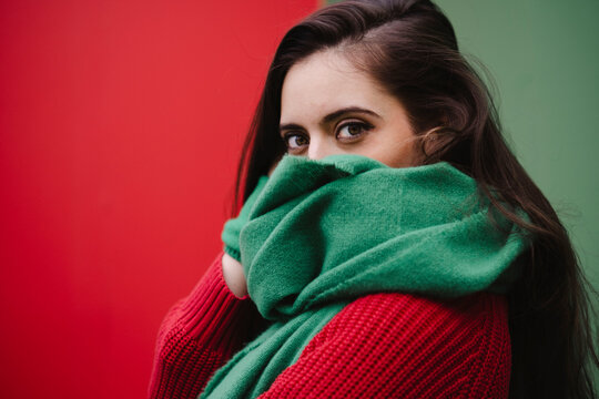 Woman covering face with green scarf