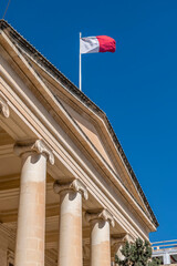 The Maltese flag flies on the Courts of Justice building in the historic center of Valletta, Malta