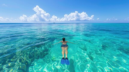 Joy and freedom of swimming in the clear,blue ocean The swimmer,equipped with snorkeling gear,is immersed in the marine world,surrounded by the serene beauty