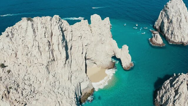 Incredibly gorgeous aerial drone panoramic of a exotic rocky cliff faces amidst striking blue aqua ocean water.