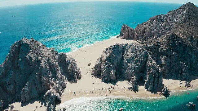 Incredibly gorgeous aerial drone panoramic of an exotic rocky sandy beach with striking blue water.