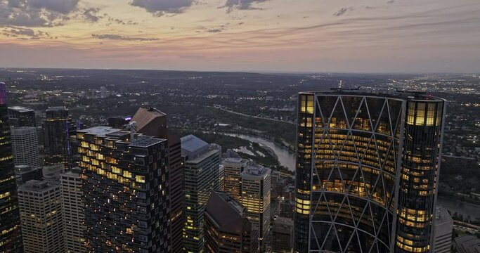 Calgary AB Canada Aerial v66 drone flyover and around the skyscraper of The Bow business centre capturing illuminated downtown cityscape and sunset dusk sky - Shot with Mavic 3 Pro Cine - July 2023