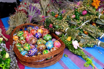 Beautiful handmade colorful Easter eggs in a basket and Easter palms on stall during fier. Kurpie, Poland	