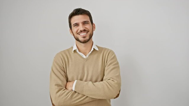 Young hispanic man wearing sweater standing happy face smiling with crossed arms looking at the camera. positive person. over isolated white background