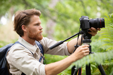 photographer man with professional camera on tripod shooting wildlife - 769568808