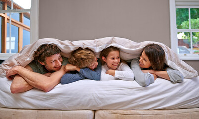 Bedroom, blanket and parents with children, family and happiness with smile and bonding together....