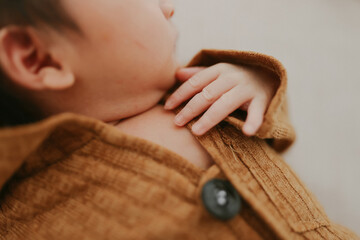 Tender Beginnings. A newborn’s delicate hand rests on a cozy woolen blanket, bathed in soft...