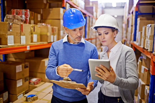 Warehouse, man and woman with tablet, teamwork and inspecting inventory with cooperation. Large distribution, supervisor and management with technology and update schedule with app and industrial