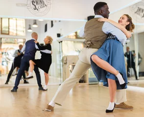 Cercles muraux École de danse Woman with american man practising ballroom dancing