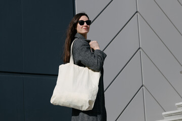 White tote bag or eco cotton bag in woman's hand