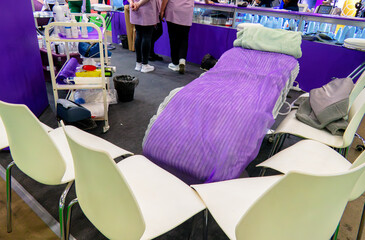 A room with a purple-covered cosmetic chair and several chairs around it. Room for training in cosmetic procedures. Chairs are arranged in a semicircle around the table
