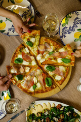 Pizza with prosciutto and cheese on the wooden table