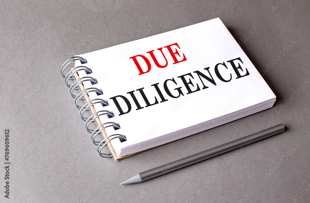 Poster due diligence text on notebook on grey background