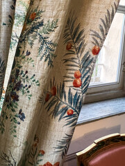 A closeup of a curtain with floral pattern resembling temporary tattoo art