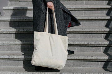 White tote bag or eco cotton bag in woman's hand