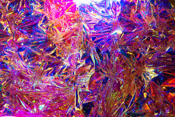 The background is a colorful shiny red surface that appears to be made of glass or foil. The surface has a unique texture and appears to be a combination of shiny plastic and reflective material.