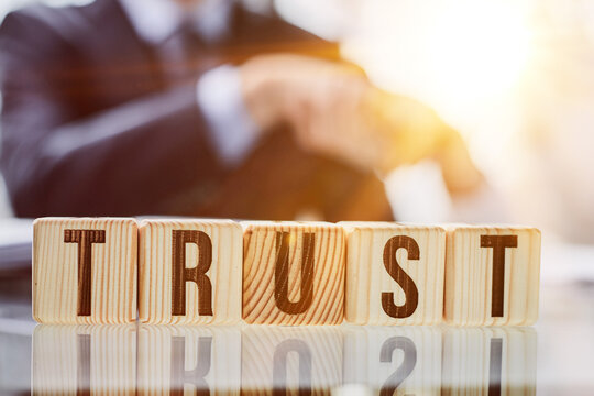 Wooden blocks with the word Trust. Trust relationships between business partners, friends, relatives.