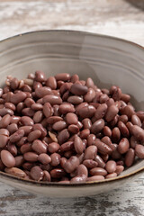 Kidney beans in a bowl on a rustic wooden background.