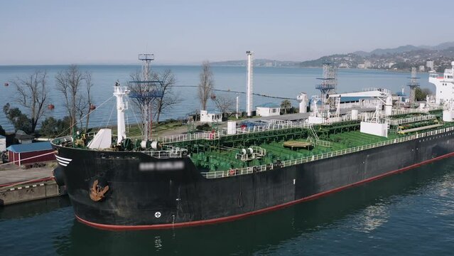 Large tanker ship at port with clear blue skies.