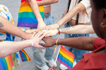 A group of people holding hands and holding rainbow flags