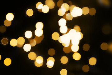 Colorful defocused bokeh lights blur sparkling dark background Gold lights Golden sparks glowing...