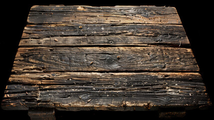 A wooden table with a black background. The table is old and has a lot of scratches and dents. The wood is dark brown and has a rough texture. The table appears to be in a state of disrepair - obrazy, fototapety, plakaty