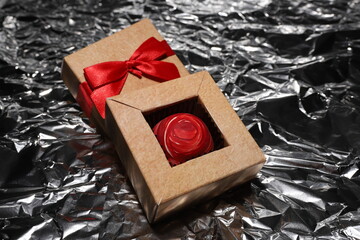 Candy box with tea rose. Box with a red bow on a silver background.