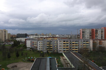 Five-story houses in a residential area. Bright facade of houses. Sky with dark clouds before a storm. Storm warning in the city.