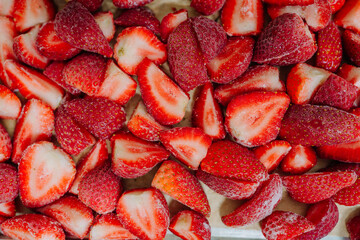 Close-up of freshly sliced frozen strawberries with vibrant red color and seeds visible