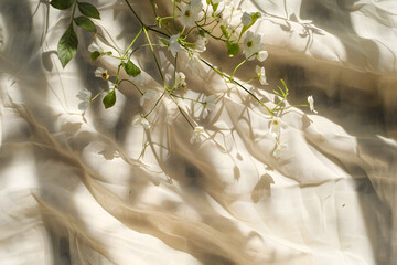 Floral sunlight shadows on a neutral beige cloth, aesthetic minimalist natural background with copy space