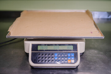 A digital scale with an empty tray on it displaying a weight of 0.600 kilograms in a food...