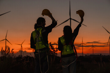 Engineer and energy farming. Wind turbine with the silhouette of sunset background. - 769640462