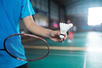 Close up side view badminton serving forehand position with racket and shuttlecock, competitive racket sport activity and leisure concept copyspace. - obrazy, fototapety, plakaty