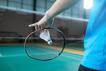 Close up back view badminton serving backhand position with racket and shuttlecock, competitive racket sport activity and leisure concept copyspace. - obrazy, fototapety, plakaty