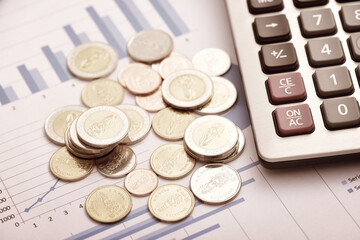 Coins and calculators placed on financial data reports
